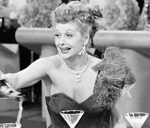 Lucille Ball wigs out from stress while pouring a drink at a party.