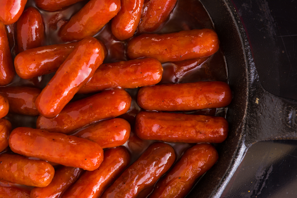 Little smokies being cooked in a skillet.