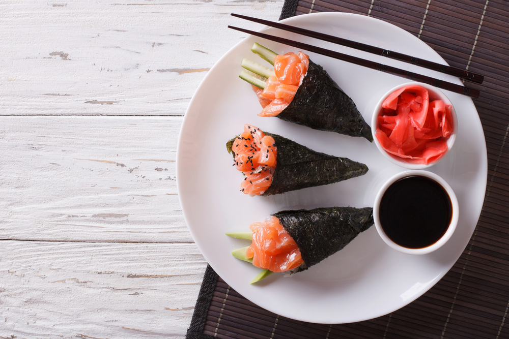 Three temaki rolls with soy sauce and ginger eggs