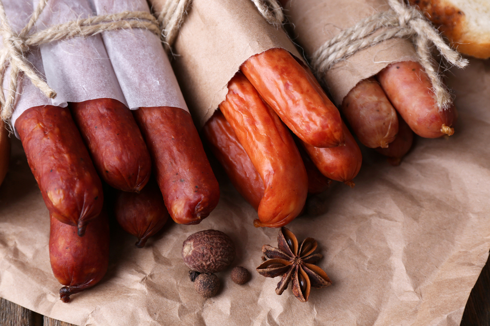 Bundles of smoked sausages wrapped in butcher paper and twine.