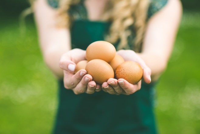 A girl wearing a green shirt offers some of the healthiest food you can eat: eggs!
