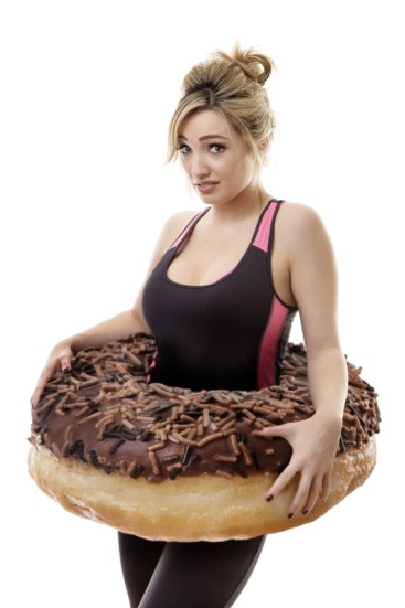 A pretty woman wears a large doughnut around her waist, is she big-boned?