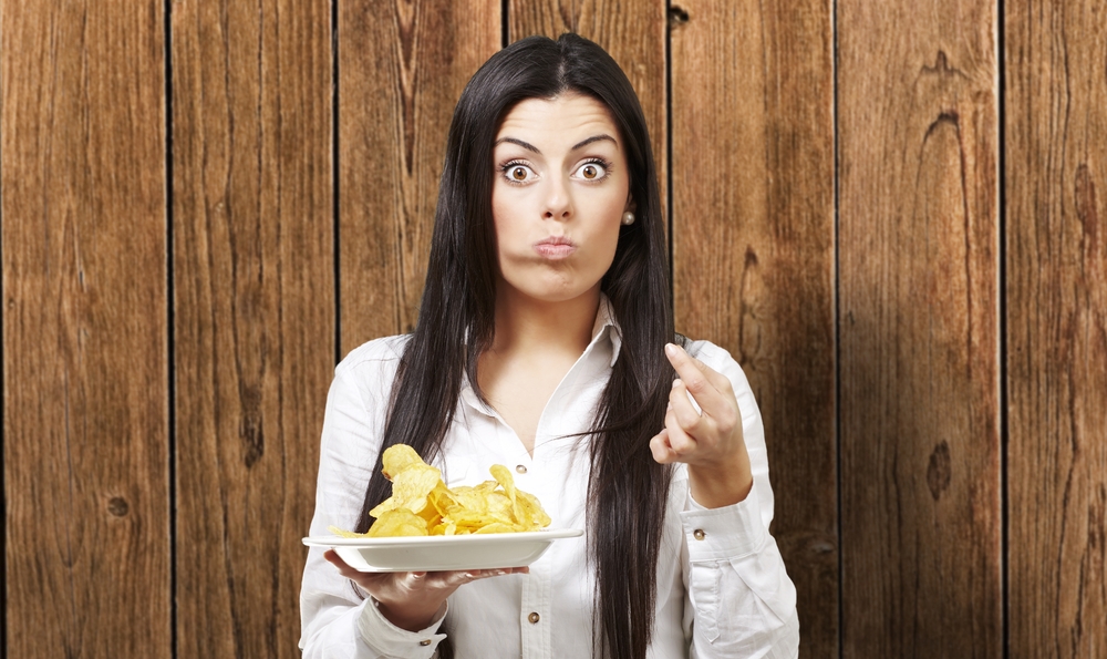 Woman eating a plate of chips.