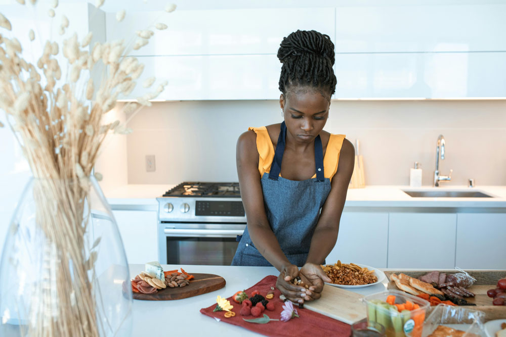 Woman preparing low GI meals with balanced ingredients in the kitchen